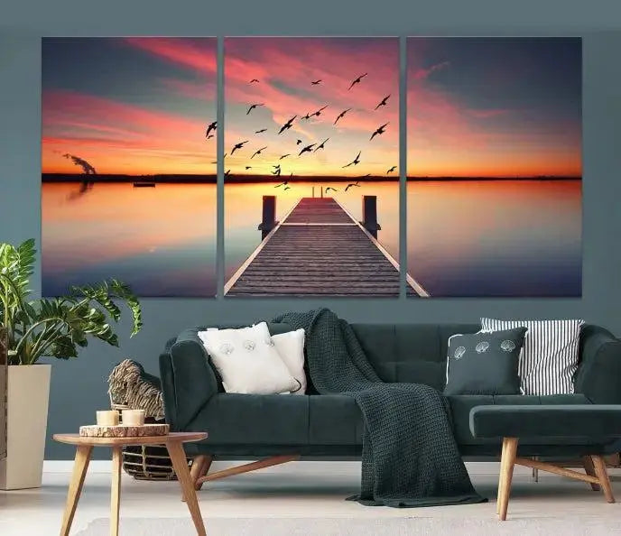 The Wood Bridge and Sunset Wall Art Canvas Print showcases a tranquil sunset scene featuring a wooden dock, soaring birds, and a vibrant sky. It comes ready to hang.