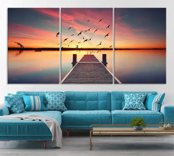 The Wood Bridge and Sunset Wall Art Canvas Print showcases a tranquil sunset scene featuring a wooden dock, soaring birds, and a vibrant sky. It comes ready to hang.