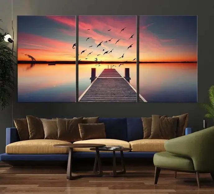 The Wood Bridge and Sunset Wall Art Canvas Print showcases a tranquil sunset scene featuring a wooden dock, soaring birds, and a vibrant sky. It comes ready to hang.