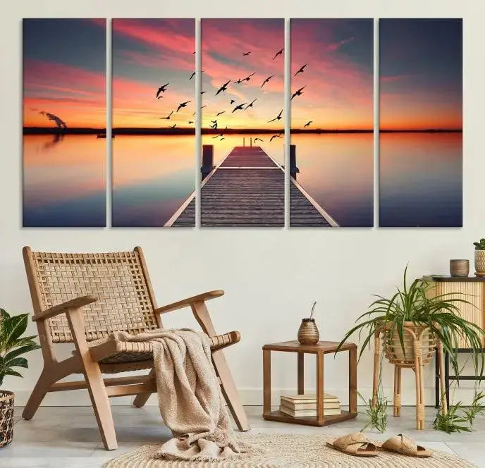 The Wood Bridge and Sunset Wall Art Canvas Print showcases a tranquil sunset scene featuring a wooden dock, soaring birds, and a vibrant sky. It comes ready to hang.