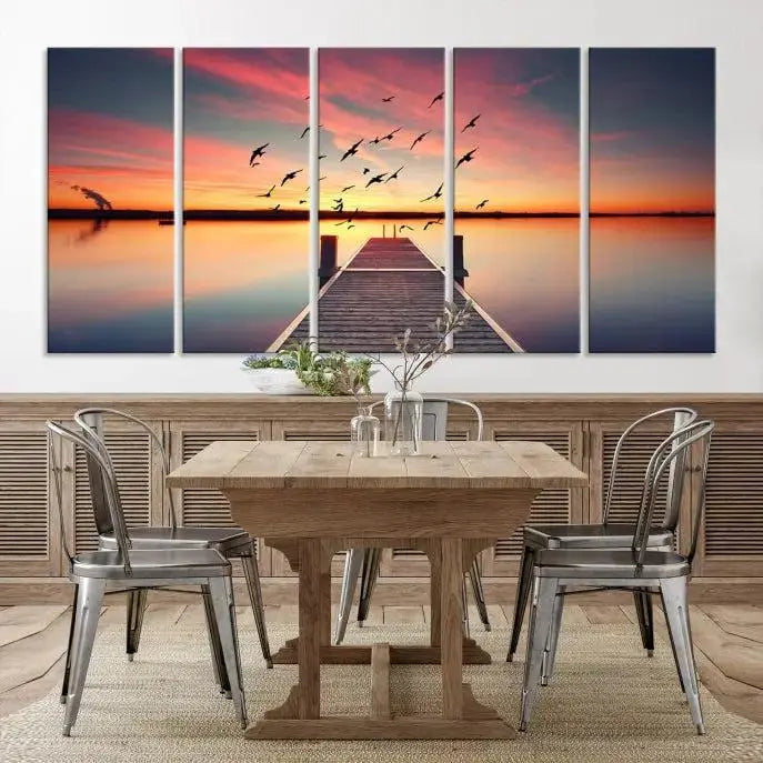 The Wood Bridge and Sunset Wall Art Canvas Print showcases a tranquil sunset scene featuring a wooden dock, soaring birds, and a vibrant sky. It comes ready to hang.