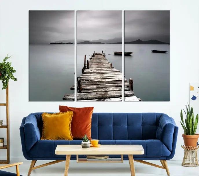 The Wood Pier Wall Art Canvas Print, a triptych featuring a wooden pier stretching into a tranquil, misty lake, is elegantly displayed in the room. This gallery-wrapped artwork is crafted from museum-quality polycotton and includes a UV-protective coating to ensure durability and vibrant colors for years to come.