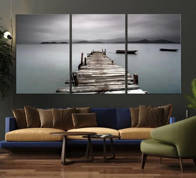 The Wood Pier Wall Art Canvas Print, a triptych featuring a wooden pier stretching into a tranquil, misty lake, is elegantly displayed in the room. This gallery-wrapped artwork is crafted from museum-quality polycotton and includes a UV-protective coating to ensure durability and vibrant colors for years to come.