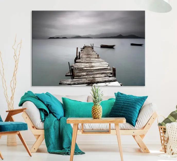 The Wood Pier Wall Art Canvas Print, a triptych featuring a wooden pier stretching into a tranquil, misty lake, is elegantly displayed in the room. This gallery-wrapped artwork is crafted from museum-quality polycotton and includes a UV-protective coating to ensure durability and vibrant colors for years to come.