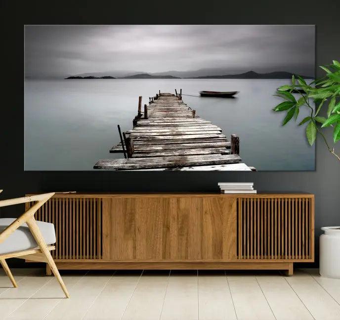 The Wood Pier Wall Art Canvas Print, a triptych featuring a wooden pier stretching into a tranquil, misty lake, is elegantly displayed in the room. This gallery-wrapped artwork is crafted from museum-quality polycotton and includes a UV-protective coating to ensure durability and vibrant colors for years to come.