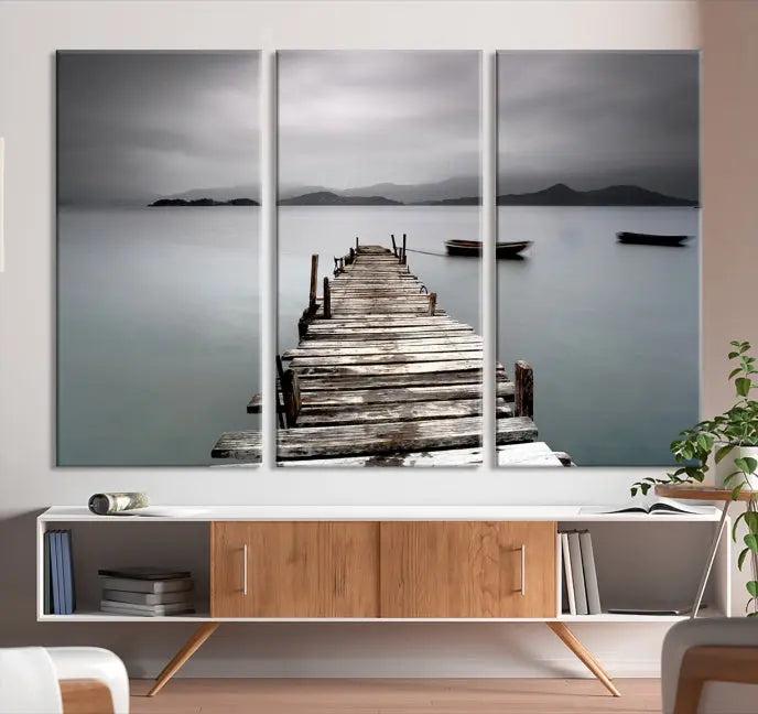 The Wood Pier Wall Art Canvas Print, a triptych featuring a wooden pier stretching into a tranquil, misty lake, is elegantly displayed in the room. This gallery-wrapped artwork is crafted from museum-quality polycotton and includes a UV-protective coating to ensure durability and vibrant colors for years to come.