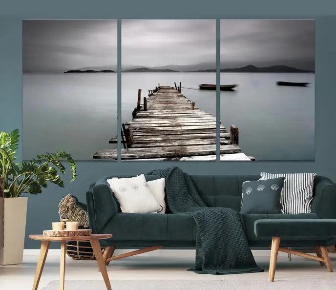 The Wood Pier Wall Art Canvas Print, a triptych featuring a wooden pier stretching into a tranquil, misty lake, is elegantly displayed in the room. This gallery-wrapped artwork is crafted from museum-quality polycotton and includes a UV-protective coating to ensure durability and vibrant colors for years to come.