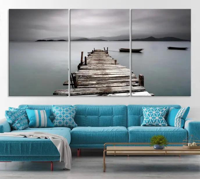 The Wood Pier Wall Art Canvas Print, a triptych featuring a wooden pier stretching into a tranquil, misty lake, is elegantly displayed in the room. This gallery-wrapped artwork is crafted from museum-quality polycotton and includes a UV-protective coating to ensure durability and vibrant colors for years to come.