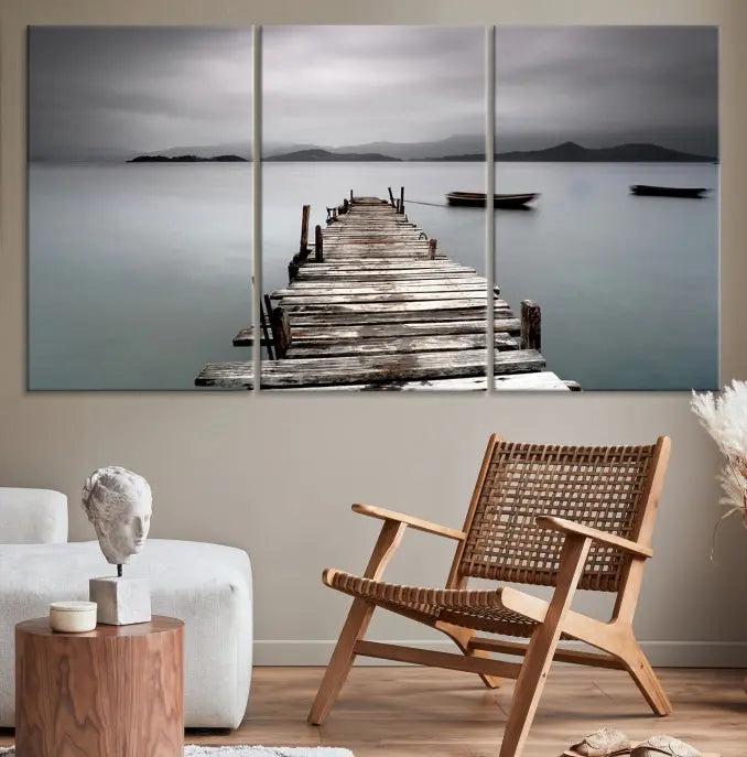 The Wood Pier Wall Art Canvas Print, a triptych featuring a wooden pier stretching into a tranquil, misty lake, is elegantly displayed in the room. This gallery-wrapped artwork is crafted from museum-quality polycotton and includes a UV-protective coating to ensure durability and vibrant colors for years to come.