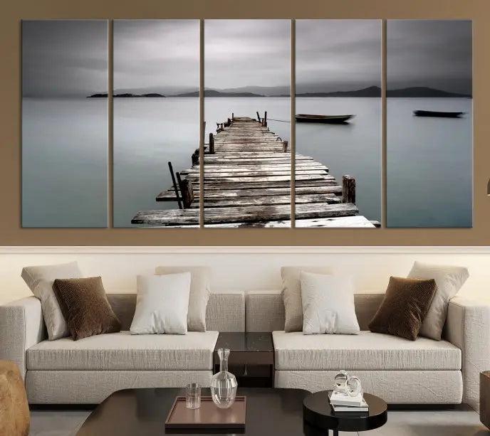 The Wood Pier Wall Art Canvas Print, a triptych featuring a wooden pier stretching into a tranquil, misty lake, is elegantly displayed in the room. This gallery-wrapped artwork is crafted from museum-quality polycotton and includes a UV-protective coating to ensure durability and vibrant colors for years to come.