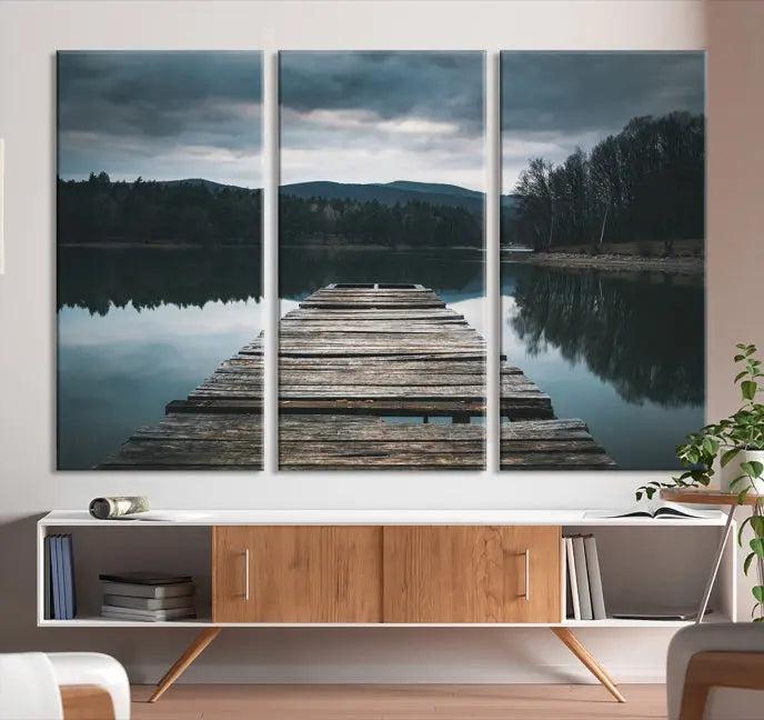 A serene triptych featuring the "Wooden Bridge Near Lake Wall Art Canvas Print" is showcased, depicting a tranquil lake with a wooden pier amidst trees and mountains on museum-quality canvas.