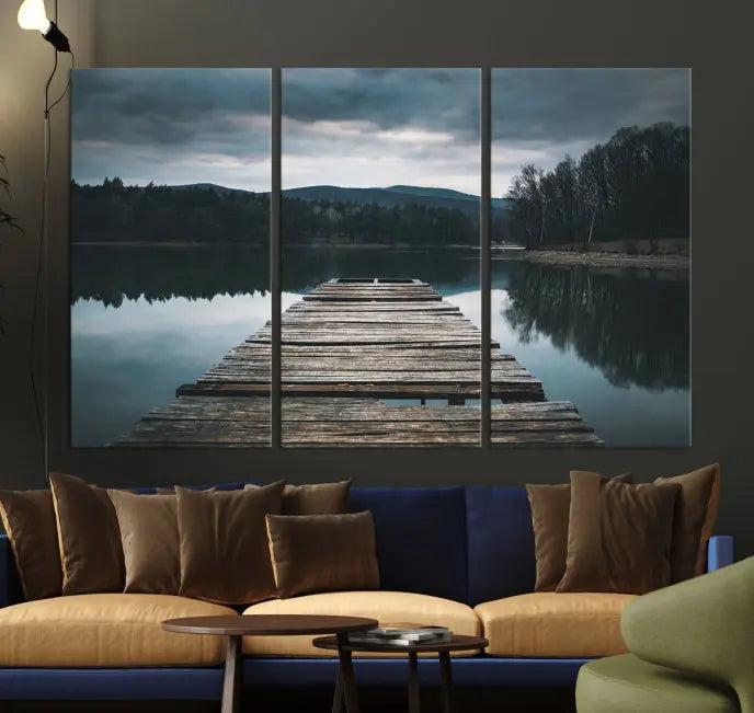 A serene triptych featuring the "Wooden Bridge Near Lake Wall Art Canvas Print" is showcased, depicting a tranquil lake with a wooden pier amidst trees and mountains on museum-quality canvas.