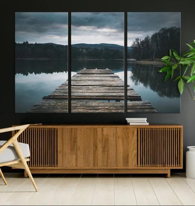 A serene triptych featuring the "Wooden Bridge Near Lake Wall Art Canvas Print" is showcased, depicting a tranquil lake with a wooden pier amidst trees and mountains on museum-quality canvas.