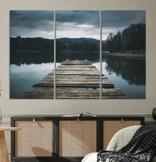 A serene triptych featuring the "Wooden Bridge Near Lake Wall Art Canvas Print" is showcased, depicting a tranquil lake with a wooden pier amidst trees and mountains on museum-quality canvas.