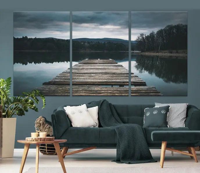 A serene triptych featuring the "Wooden Bridge Near Lake Wall Art Canvas Print" is showcased, depicting a tranquil lake with a wooden pier amidst trees and mountains on museum-quality canvas.