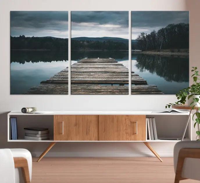 A serene triptych featuring the "Wooden Bridge Near Lake Wall Art Canvas Print" is showcased, depicting a tranquil lake with a wooden pier amidst trees and mountains on museum-quality canvas.