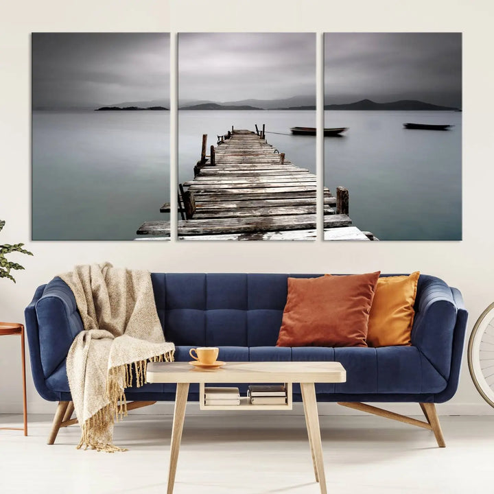 A serene triptych featuring a wooden pier stretching into misty waters brings the Wooden Pier Canvas Wall Art Beach Canvas Artwork Print to life.