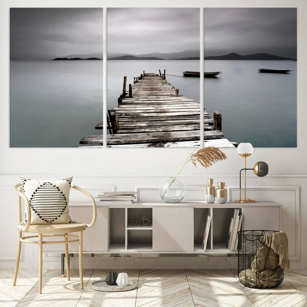 A serene triptych featuring a wooden pier stretching into misty waters brings the Wooden Pier Canvas Wall Art Beach Canvas Artwork Print to life.