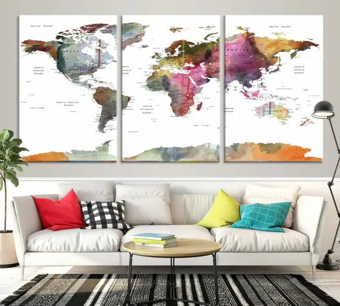 A set of three "World Map Push Pin Travel Canvas Prints" in vibrant colors adorns the dark wall.