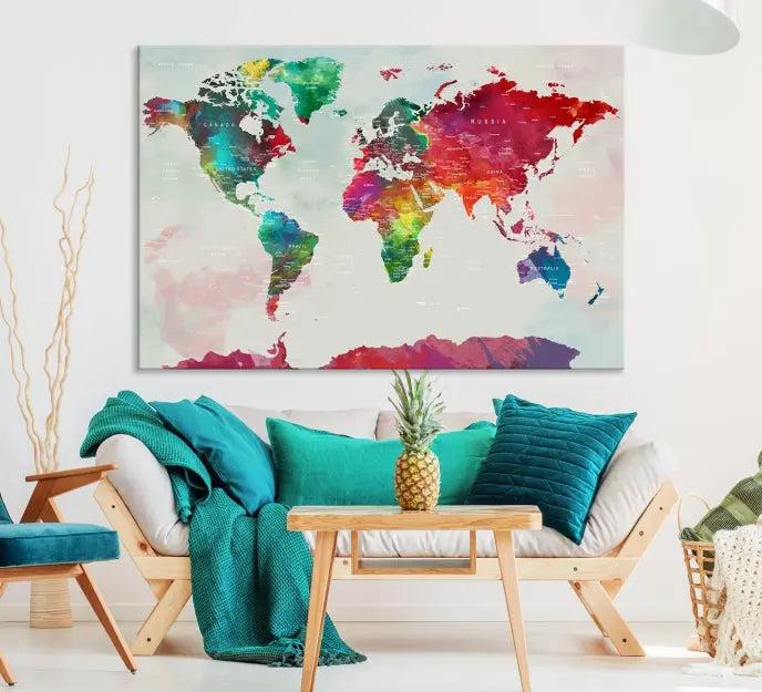 The World Map Wall Art, featuring a triptych design with vibrant continents, is printed on museum-quality canvases and displayed against a dark wall.