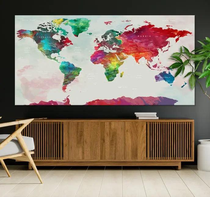 The World Map Wall Art, featuring a triptych design with vibrant continents, is printed on museum-quality canvases and displayed against a dark wall.