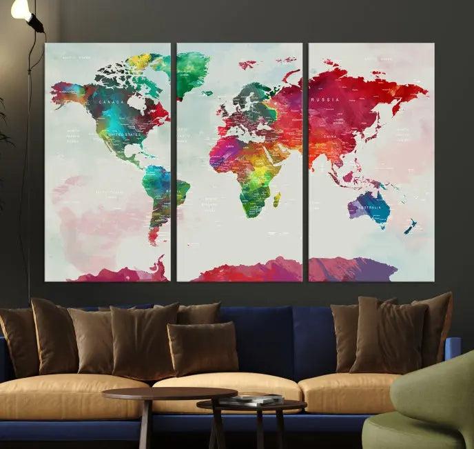 The World Map Wall Art, featuring a triptych design with vibrant continents, is printed on museum-quality canvases and displayed against a dark wall.