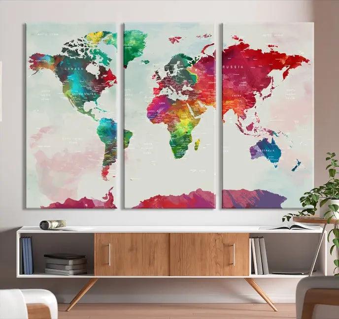 The World Map Wall Art, featuring a triptych design with vibrant continents, is printed on museum-quality canvases and displayed against a dark wall.