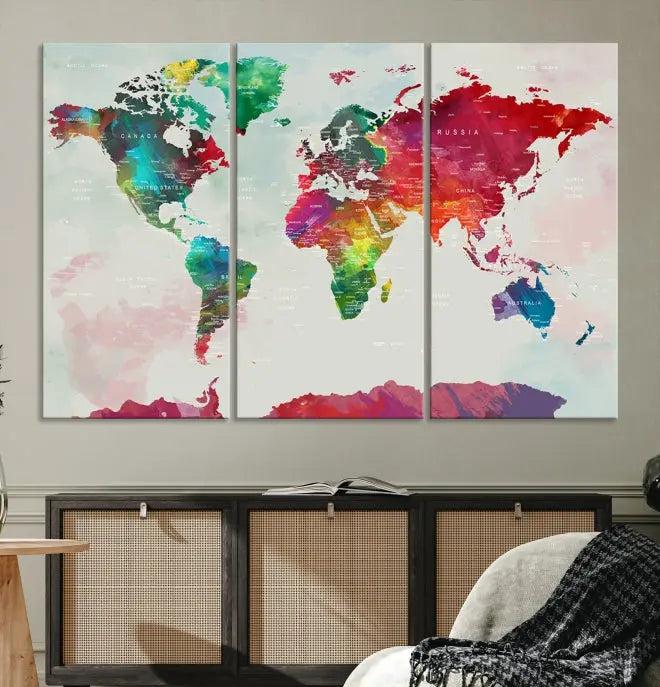 The World Map Wall Art, featuring a triptych design with vibrant continents, is printed on museum-quality canvases and displayed against a dark wall.