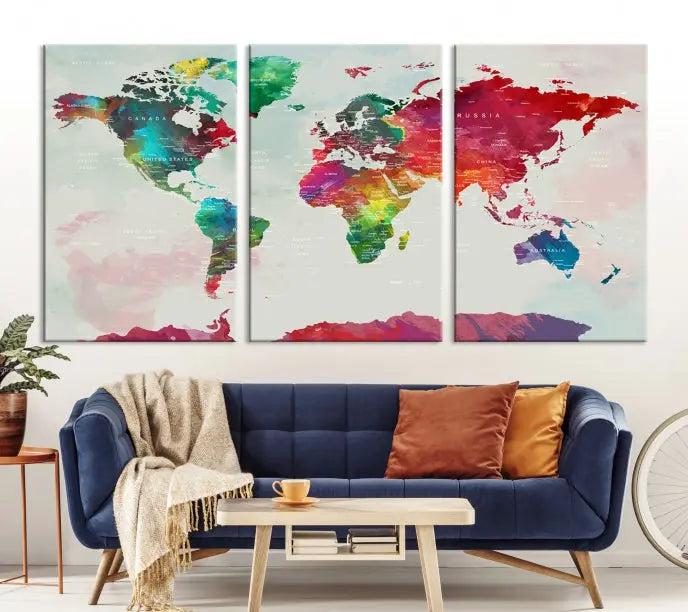 The World Map Wall Art, featuring a triptych design with vibrant continents, is printed on museum-quality canvases and displayed against a dark wall.