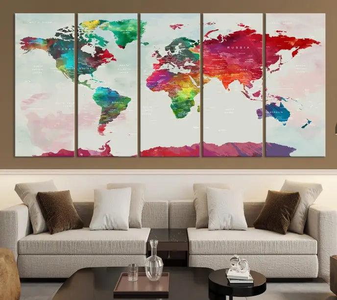 The World Map Wall Art, featuring a triptych design with vibrant continents, is printed on museum-quality canvases and displayed against a dark wall.