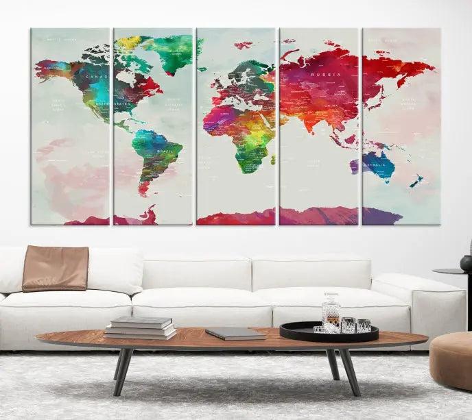 The World Map Wall Art, featuring a triptych design with vibrant continents, is printed on museum-quality canvases and displayed against a dark wall.