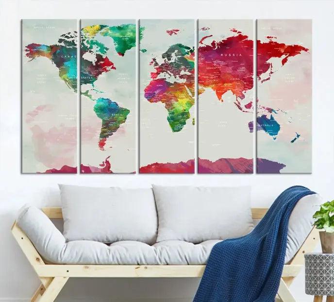 The World Map Wall Art, featuring a triptych design with vibrant continents, is printed on museum-quality canvases and displayed against a dark wall.