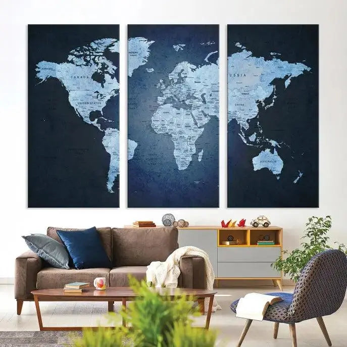 A modern living room featuring a World Map Wall Art Canvas Print in triptych format.