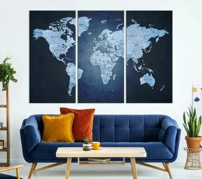 A modern living room featuring a World Map Wall Art Canvas Print in triptych format.