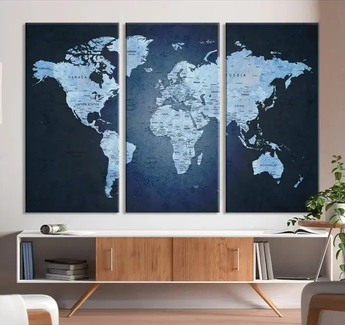 A modern living room featuring a World Map Wall Art Canvas Print in triptych format.