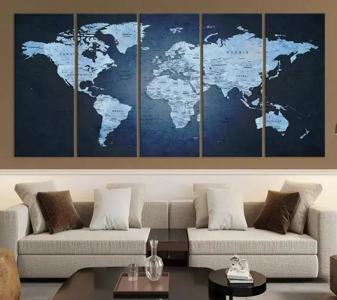 A modern living room featuring a World Map Wall Art Canvas Print in triptych format.