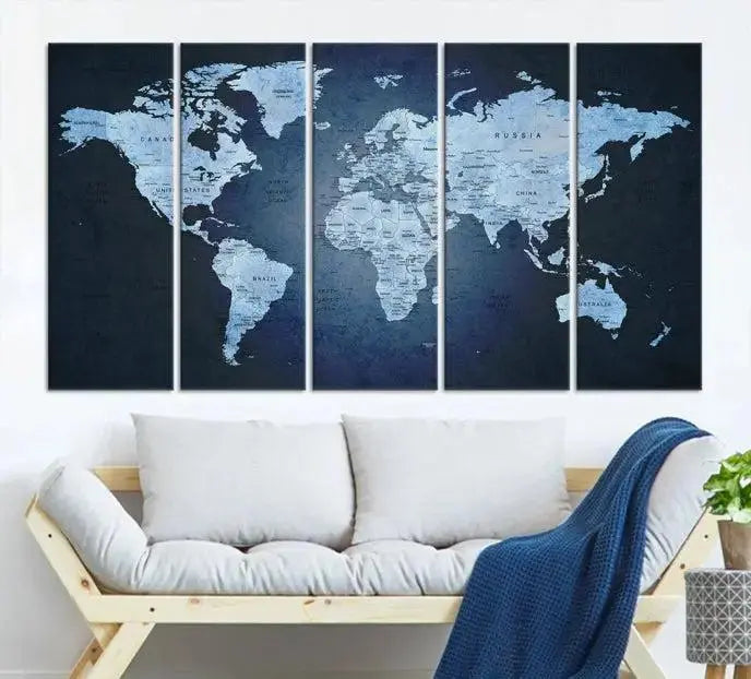 A modern living room featuring a World Map Wall Art Canvas Print in triptych format.