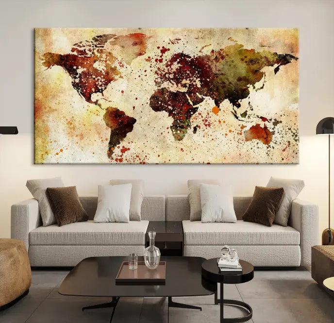 The World Map Wall Art Canvas Print, gallery-wrapped on museum-quality canvas adorned with watercolor splatters, enhances a modern living room decor. This artwork features a UV-protective coating to maintain its vibrant colors and elegant appearance over time.