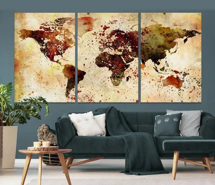 The World Map Wall Art Canvas Print, gallery-wrapped on museum-quality canvas adorned with watercolor splatters, enhances a modern living room decor. This artwork features a UV-protective coating to maintain its vibrant colors and elegant appearance over time.