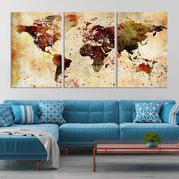 The World Map Wall Art Canvas Print, gallery-wrapped on museum-quality canvas adorned with watercolor splatters, enhances a modern living room decor. This artwork features a UV-protective coating to maintain its vibrant colors and elegant appearance over time.