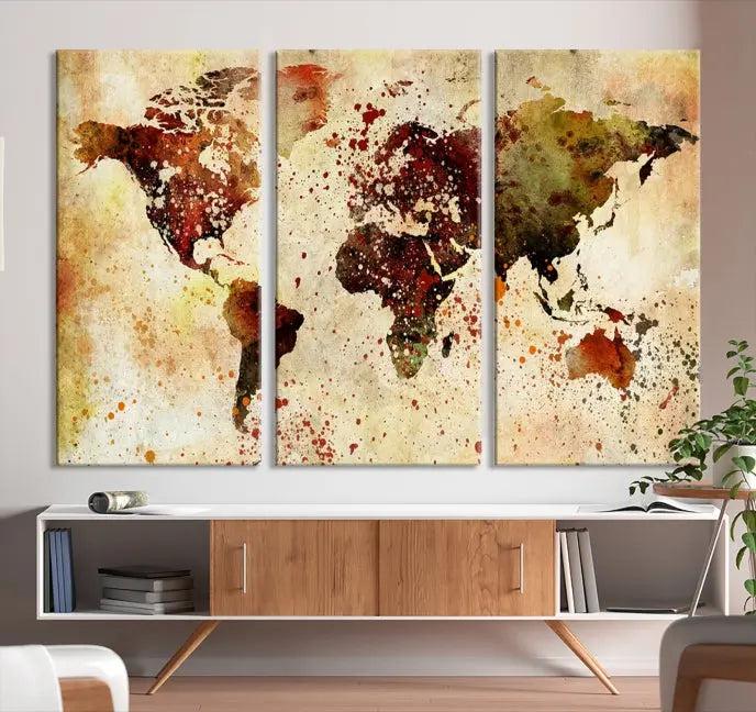 The World Map Wall Art Canvas Print, gallery-wrapped on museum-quality canvas adorned with watercolor splatters, enhances a modern living room decor. This artwork features a UV-protective coating to maintain its vibrant colors and elegant appearance over time.