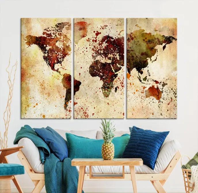 The World Map Wall Art Canvas Print, gallery-wrapped on museum-quality canvas adorned with watercolor splatters, enhances a modern living room decor. This artwork features a UV-protective coating to maintain its vibrant colors and elegant appearance over time.