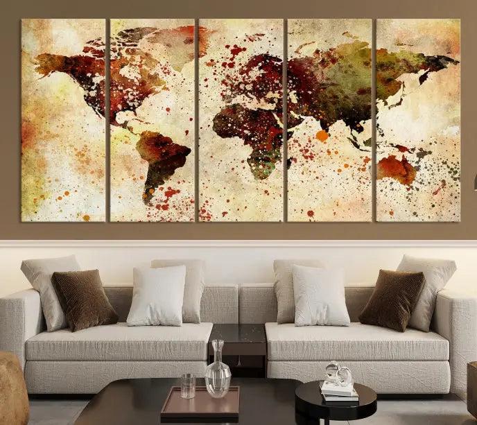 The World Map Wall Art Canvas Print, gallery-wrapped on museum-quality canvas adorned with watercolor splatters, enhances a modern living room decor. This artwork features a UV-protective coating to maintain its vibrant colors and elegant appearance over time.