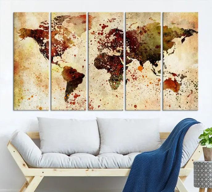 The World Map Wall Art Canvas Print, gallery-wrapped on museum-quality canvas adorned with watercolor splatters, enhances a modern living room decor. This artwork features a UV-protective coating to maintain its vibrant colors and elegant appearance over time.