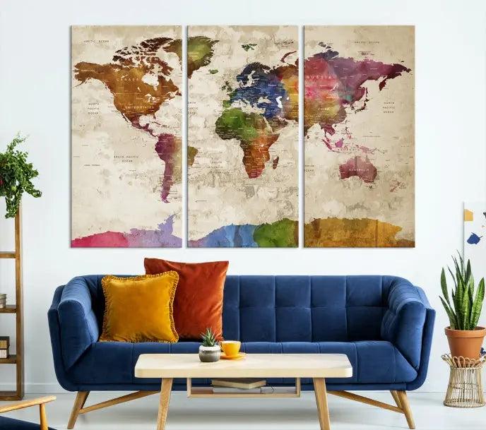 The World Map Wall Art Canvas Print, featuring a vibrant triptych design on museum-quality canvases, decorates the wall. The gallery-wrapped artwork is treated with a UV-protective coating to ensure its colors remain vivid over time.