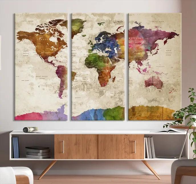 The World Map Wall Art Canvas Print, featuring a vibrant triptych design on museum-quality canvases, decorates the wall. The gallery-wrapped artwork is treated with a UV-protective coating to ensure its colors remain vivid over time.