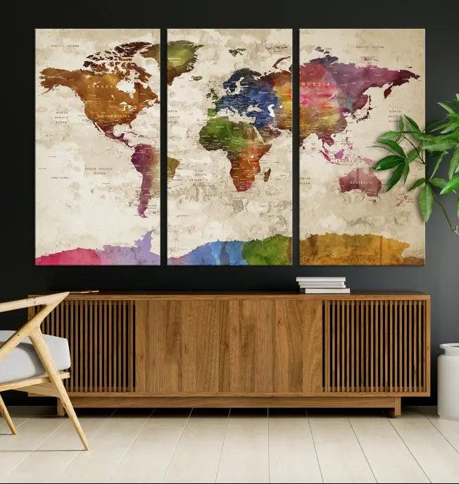 The World Map Wall Art Canvas Print, featuring a vibrant triptych design on museum-quality canvases, decorates the wall. The gallery-wrapped artwork is treated with a UV-protective coating to ensure its colors remain vivid over time.