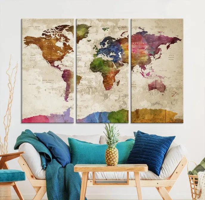 The World Map Wall Art Canvas Print, featuring a vibrant triptych design on museum-quality canvases, decorates the wall. The gallery-wrapped artwork is treated with a UV-protective coating to ensure its colors remain vivid over time.