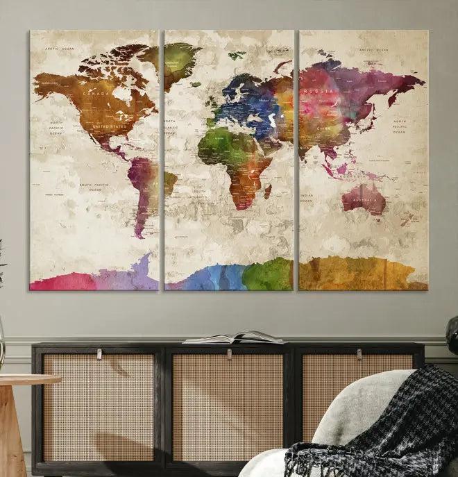 The World Map Wall Art Canvas Print, featuring a vibrant triptych design on museum-quality canvases, decorates the wall. The gallery-wrapped artwork is treated with a UV-protective coating to ensure its colors remain vivid over time.