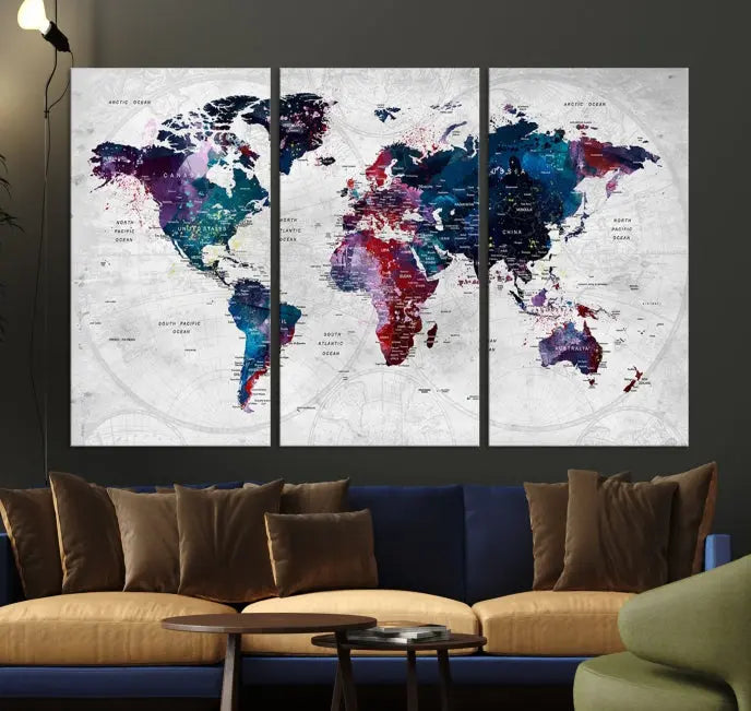 The "World Map Wall Art Watercolor Wall Art Canvas Print," a triptych featuring a vibrant world map, is gallery wrapped on museum-quality canvas and enhances the dark wall.